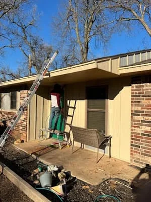 Residential home with new roofing installation, brick and siding exterior, ladder and equipment visible