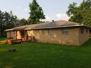 New asphalt shingle roof installed on single-story brick home with pitched roof design