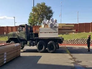 Loaded roofing supply truck with materials staged at job site