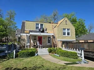 Two-story home with new asphalt shingle roof, vinyl siding, and white picket fence
