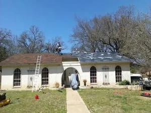 New asphalt shingle roof installed on white residential home with pitched roof design