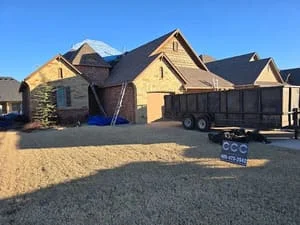 New residential roof installation with architectural shingles and multiple peaks on stone and brick home