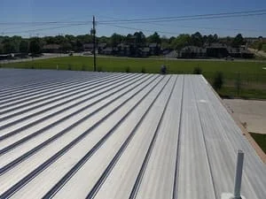 Standing seam metal roof with white finish and parallel ribs on residential structure