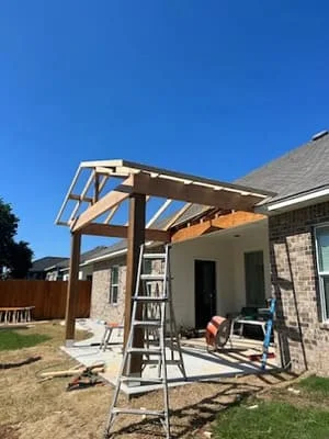 Timber patio cover frame with exposed beams and slatted roof over residential patio