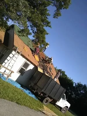 Brick home with new asphalt shingle roof installation and structural repairs in progress