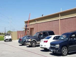 Flat commercial roof installation on brick building with new gutters and fascia