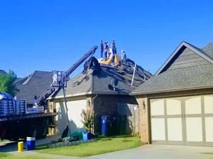 Two-story home with new asphalt shingle roof installation in progress
